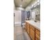 Well-lit bathroom with wood cabinets, a bathtub with shower, and neutral tiled floors at 1654 Muirfield Ln, Evergreen, CO 80439