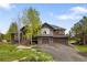 Two-story house with a two-car garage, natural landscaping, and a basketball hoop at 1654 Muirfield Ln, Evergreen, CO 80439