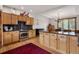 This kitchen features wood cabinets, a black countertop, stainless steel appliances, and a large island at 1654 Muirfield Ln, Evergreen, CO 80439