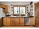 This cozy kitchen has wood cabinets, stainless appliances and a window overlooking mature trees at 1654 Muirfield Ln, Evergreen, CO 80439