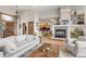 Open-concept living space with a fireplace, view into the kitchen, and hardwood floors at 1654 Muirfield Ln, Evergreen, CO 80439