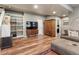 Cozy basement living room with built in shelving, a wooden entertainment center, and hardwood floors at 1654 Muirfield Ln, Evergreen, CO 80439