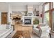 Bright living room with hardwood floors, a fireplace, and view into the kitchen at 1654 Muirfield Ln, Evergreen, CO 80439