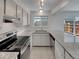 Bright kitchen featuring white cabinets, stainless steel appliances, and granite countertops at 11422 W 17Th Pl, Lakewood, CO 80215