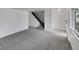 Bright living room featuring new carpeting and staircase access to upper level at 11422 W 17Th Pl, Lakewood, CO 80215