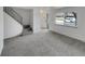 Inviting living room with new carpeting, staircase, and large windows providing natural light at 11422 W 17Th Pl, Lakewood, CO 80215