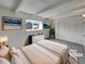 Staged main bedroom with neutral tones, beamed ceilings, an ensuite bathroom, and large closet at 11422 W 17Th Pl, Lakewood, CO 80215