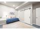 Bright bedroom featuring a sliding barn door and neutral decor at 18267 W 95Th Ave, Arvada, CO 80007