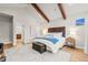 Inviting bedroom featuring beamed vaulted ceiling, a wood headboard, and ensuite bathroom access at 18267 W 95Th Ave, Arvada, CO 80007