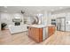 Open kitchen seamlessly transitions into the living room, featuring an island, modern appliances, and wood floors at 18267 W 95Th Ave, Arvada, CO 80007