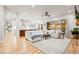 Open-concept living space featuring hardwood floors, a large white sofa, and an adjacent kitchen with bar seating at 18267 W 95Th Ave, Arvada, CO 80007