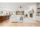 Spacious living room features hardwood floors, a large white sofa, fireplace, and an open layout to the kitchen at 18267 W 95Th Ave, Arvada, CO 80007