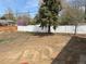 A large backyard with a mix of dirt and grass, surrounded by wooden and white fences at 201 S Monmouth Ave, Firestone, CO 80520