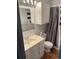 Bathroom with light fixtures, tiled shower with curtain, and vanity with mirrored cabinet at 201 S Monmouth Ave, Firestone, CO 80520