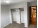 Carpeted bedroom featuring a closet with white trim and a doorway with a view of the bathroom at 201 S Monmouth Ave, Firestone, CO 80520