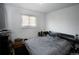 Simple bedroom with a bed, window, and a dark colored accent furniture at 201 S Monmouth Ave, Firestone, CO 80520