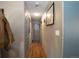 Hallway with wood-look floors, leading to the main door, with gray walls and light fixtures at 201 S Monmouth Ave, Firestone, CO 80520