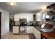 Bright kitchen features white cabinetry, stainless steel appliances, and tile backsplash at 201 S Monmouth Ave, Firestone, CO 80520