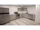 The kitchen features stainless steel appliances, gray cabinets, and wooden floating shelves at 201 S Monmouth Ave, Firestone, CO 80520