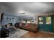 Spacious living room with a brick fireplace, a large couch, and a double door entrance at 201 S Monmouth Ave, Firestone, CO 80520