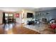 Open living room with wood floors, brick fireplace, and access to kitchen and dining area at 201 S Monmouth Ave, Firestone, CO 80520