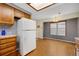 Kitchen with wood cabinets and white refrigerator adjacent to dining area at 14192 E Baltic Pl, Aurora, CO 80014