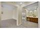 Main bathroom with double mirrored sinks, a vanity, and a doorway to the bedroom at 14192 E Baltic Pl, Aurora, CO 80014