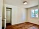 Empty bedroom with hardwood flooring, neutral walls, natural light, and a walk-in closet at 601 W Layton Ave, Englewood, CO 80110