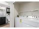 Efficient laundry space with washer and dryer setup and convenient shelving at 7860 Ogden Ct, Denver, CO 80229