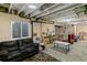 A finished basement with a gray sofa and play area with exposed ceiling and a window at 1262 High Point Trl, Elizabeth, CO 80107