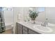 Bathroom featuring double sinks, modern fixtures, and a shower with white tile at 1262 High Point Trl, Elizabeth, CO 80107