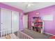 bedroom with plush carpet, dollhouse and organized closet in playful purple decor at 1262 High Point Trl, Elizabeth, CO 80107
