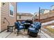 An outdoor patio with comfortable blue cushioned furniture and a grill with a fenced background at 1262 High Point Trl, Elizabeth, CO 80107