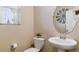 Stylish powder room features a decorative mirror, modern fixtures, and a pedestal sink at 1262 High Point Trl, Elizabeth, CO 80107