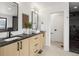 Well-lit bathroom with dual sink vanity, granite countertop, and a black marble shower at 4301 Osceola St, Denver, CO 80212