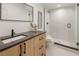 Contemporary bathroom featuring a wood vanity, dark hardware, and a glass-enclosed shower with white subway tile at 4301 Osceola St, Denver, CO 80212