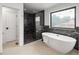Luxurious bathroom featuring a soaking tub and a shower with marble tile surround at 4301 Osceola St, Denver, CO 80212