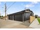 Modern two-car garage featuring sleek black doors and contemporary exterior lighting, plus privacy fence at 4301 Osceola St, Denver, CO 80212