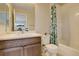 Bright bathroom featuring a modern vanity, toilet, and shower with tropical-patterned curtain at 16102 E 47Th Pl, Denver, CO 80239