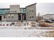 Modern townhome featuring clean architectural lines, a well-maintained yard, and inviting entryways in a snowy landscape at 16102 E 47Th Pl, Denver, CO 80239