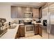 Modern kitchen with stainless steel appliances and dark wood cabinets at 16102 E 47Th Pl, Denver, CO 80239