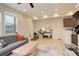 Bright living room featuring a comfortable gray sofa, modern wood coffee table, and neutral decor at 16102 E 47Th Pl, Denver, CO 80239