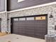Exterior of attached garage with stylish stonework and black accents at 6532 N Malaya St, Aurora, CO 80019