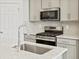 Modern kitchen with stainless steel appliances, grey cabinets, white countertops, and island at 6532 N Malaya St, Aurora, CO 80019
