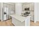 Bright kitchen features stainless steel appliances, white cabinets, and a large island with a sink at 6532 N Malaya St, Aurora, CO 80019