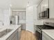Bright kitchen features stainless steel appliances, white cabinets, and a large island with a sink at 6532 N Malaya St, Aurora, CO 80019