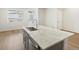 Bright kitchen features gray cabinets and a large island with a sink and stainless steel faucet at 6532 N Malaya St, Aurora, CO 80019