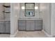 Well-lit bathroom with gray cabinets, large mirror, modern sconces, and stylish fixtures at 2690 Fox View Trl, Franktown, CO 80116