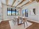 Elegant dining room with modern light fixture, wood beams, and large windows with scenic views at 2690 Fox View Trl, Franktown, CO 80116