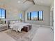 Vaulted ceiling main bedroom features a whitewashed brick wall and large windows with scenic views at 2690 Fox View Trl, Franktown, CO 80116